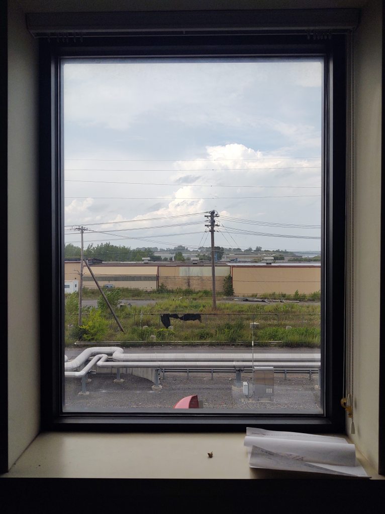 A lonely view out of a paper mill window.